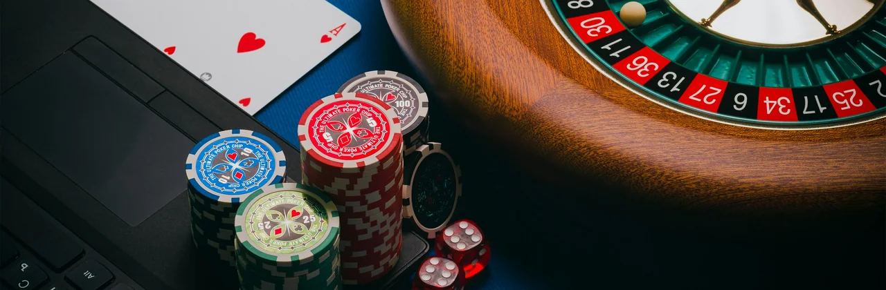 Roulette, jetons, cartes et dés sur un tapis vert foncé